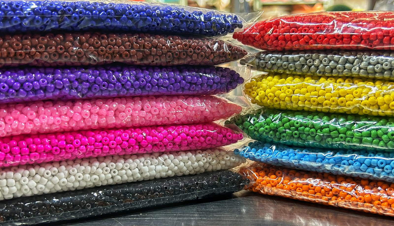 Miçangas de vidro coloridas e guias religiosas prontas dispostas sobre superfície clara